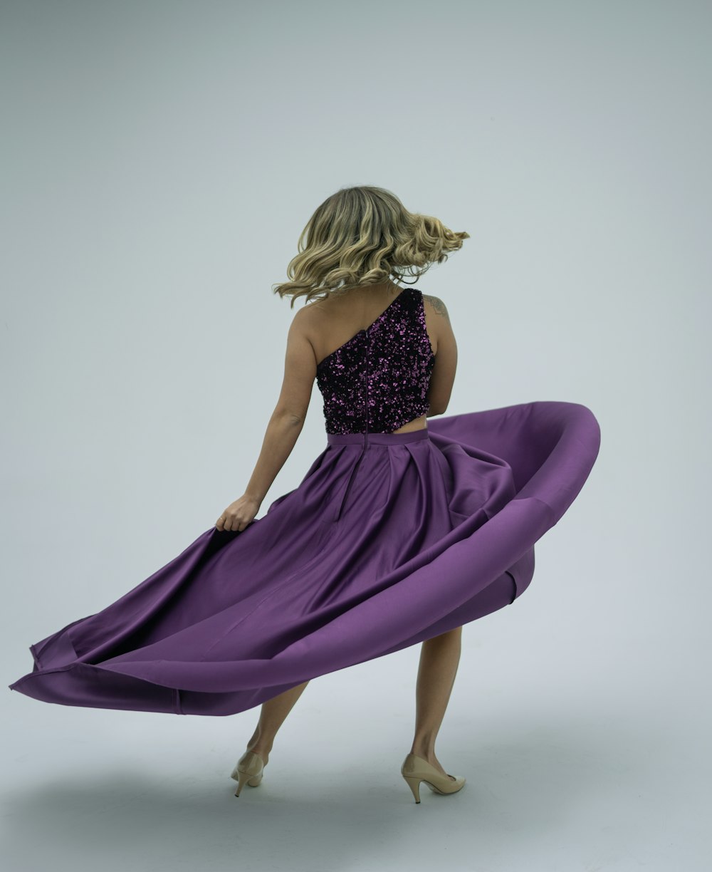 a woman in a purple dress is dancing