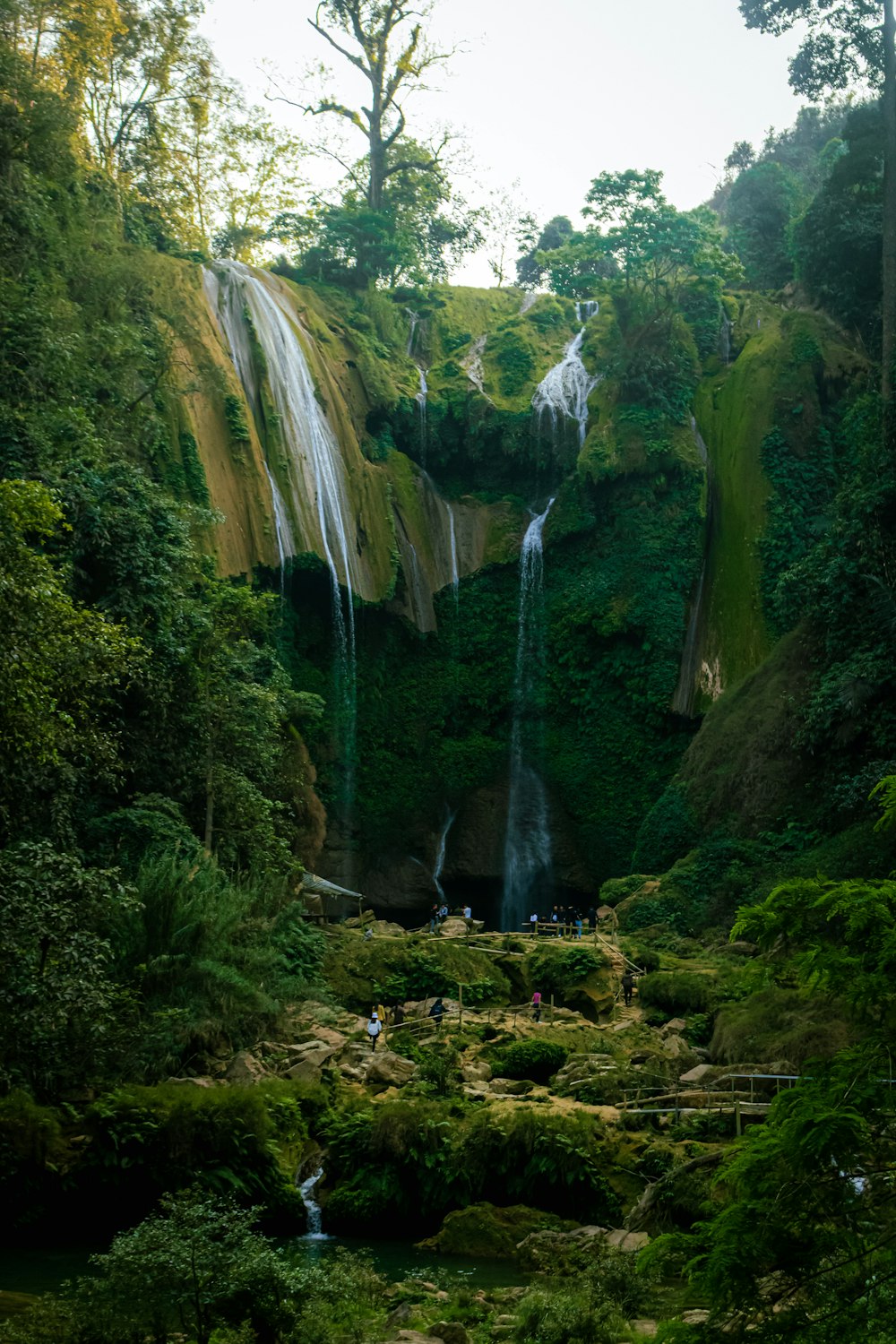 a group of people standing in front of a waterfall