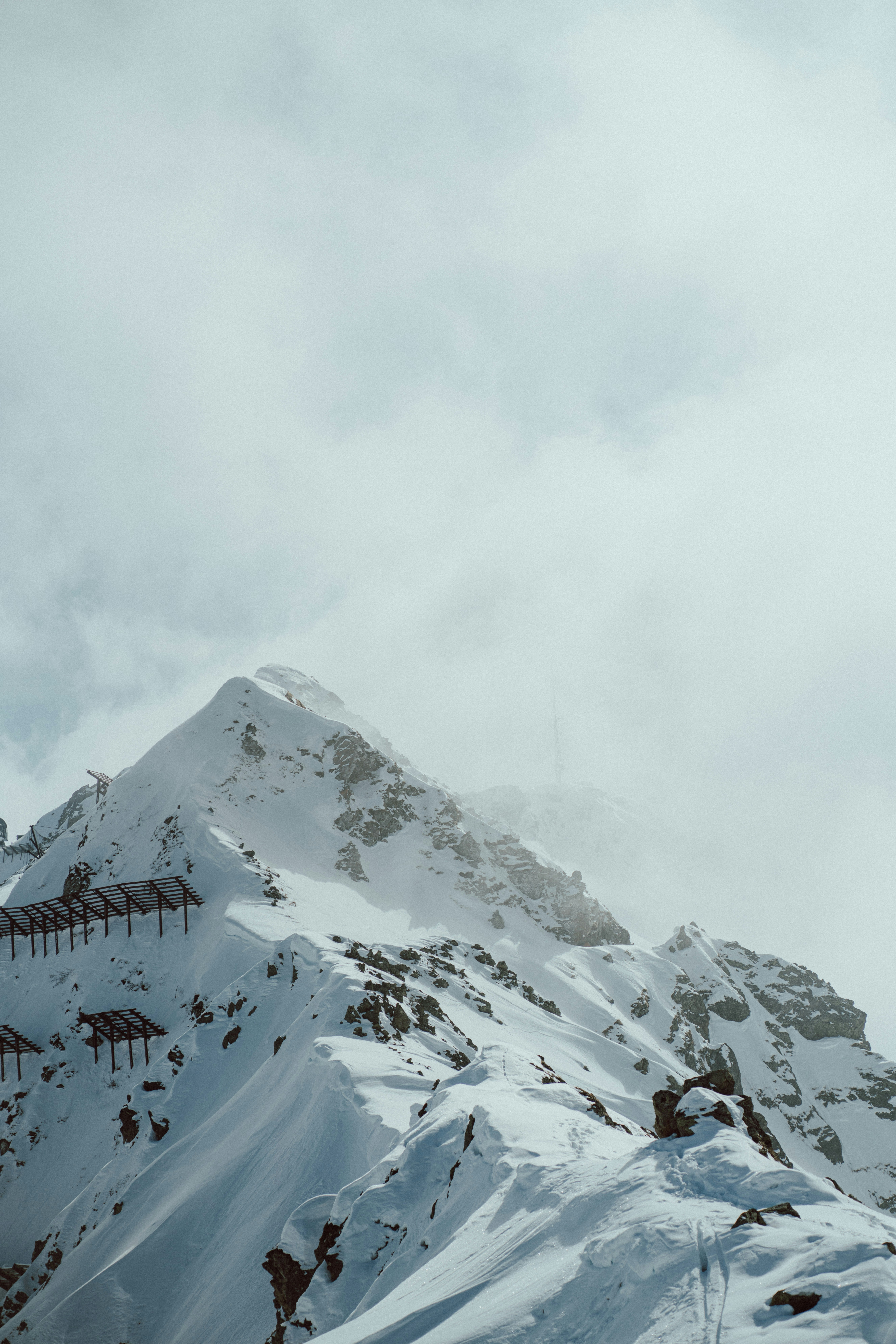 a snow covered mountain with a ski lift in the distance