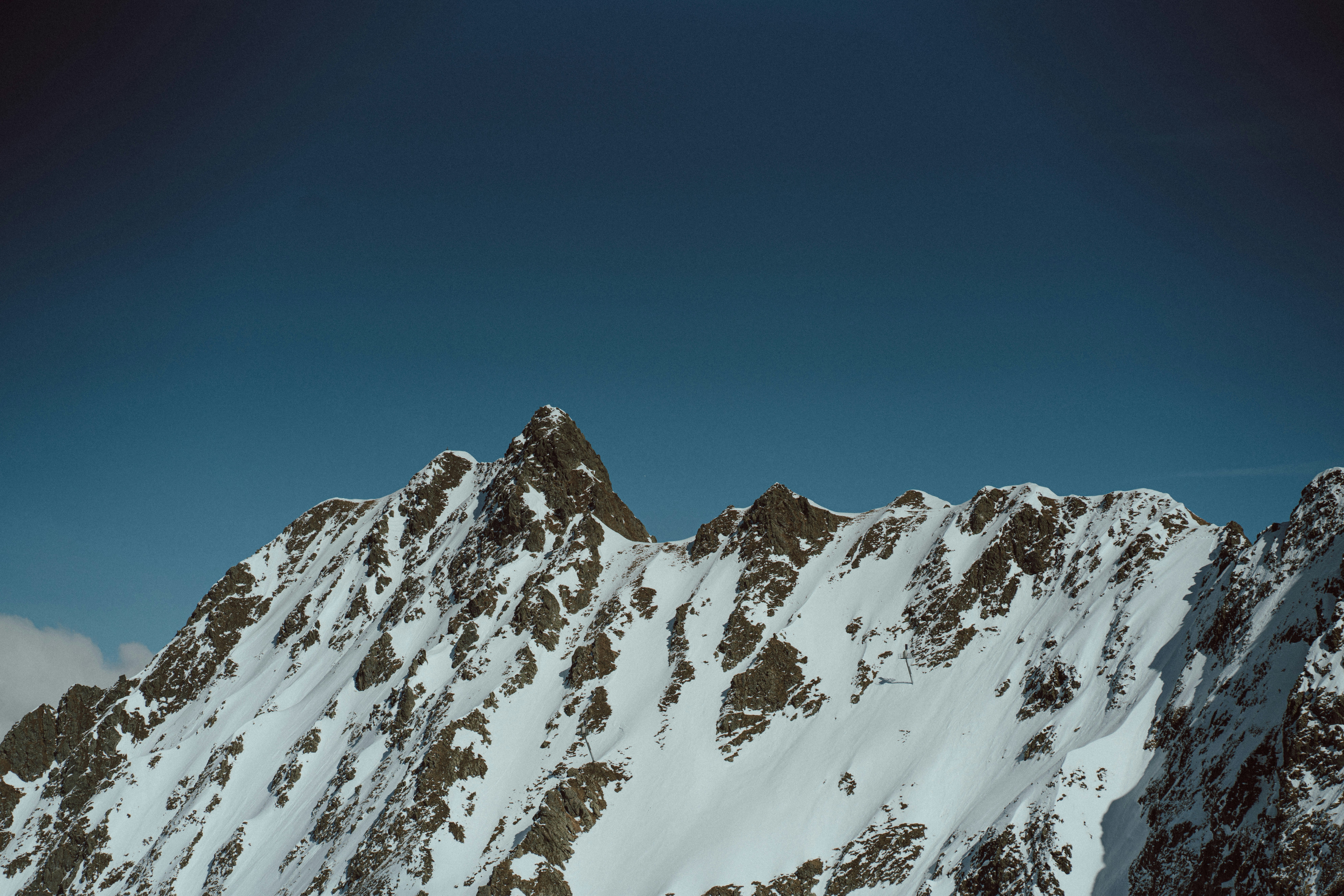 a snowboarder is going down a snowy mountain