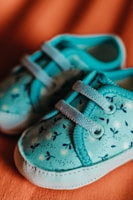 a pair of blue shoes sitting on top of a bed