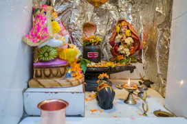 a shrine with a statue of a person and a candle