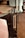 A modern kitchen area features sleek dark cabinets and a countertop with various items. Prominently placed is a red stand mixer, a black coffee maker, a red kettle, and several bottles and containers. The ambient lighting and neutral tones create a cozy atmosphere.