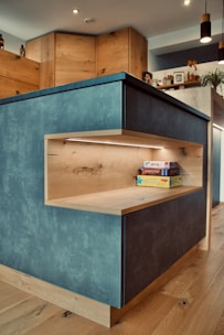 Modern kitchen with natural wood accents and soft blue tiles.