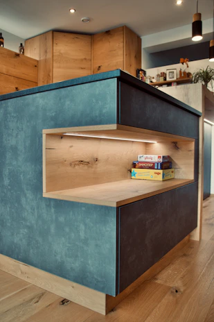 Close-up of a beautifully finished kitchen featuring sleek cabinetry and electric blue lighting highlights.