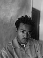 Editorial-style black and white portrait of a Congolese intellectual in a library setting