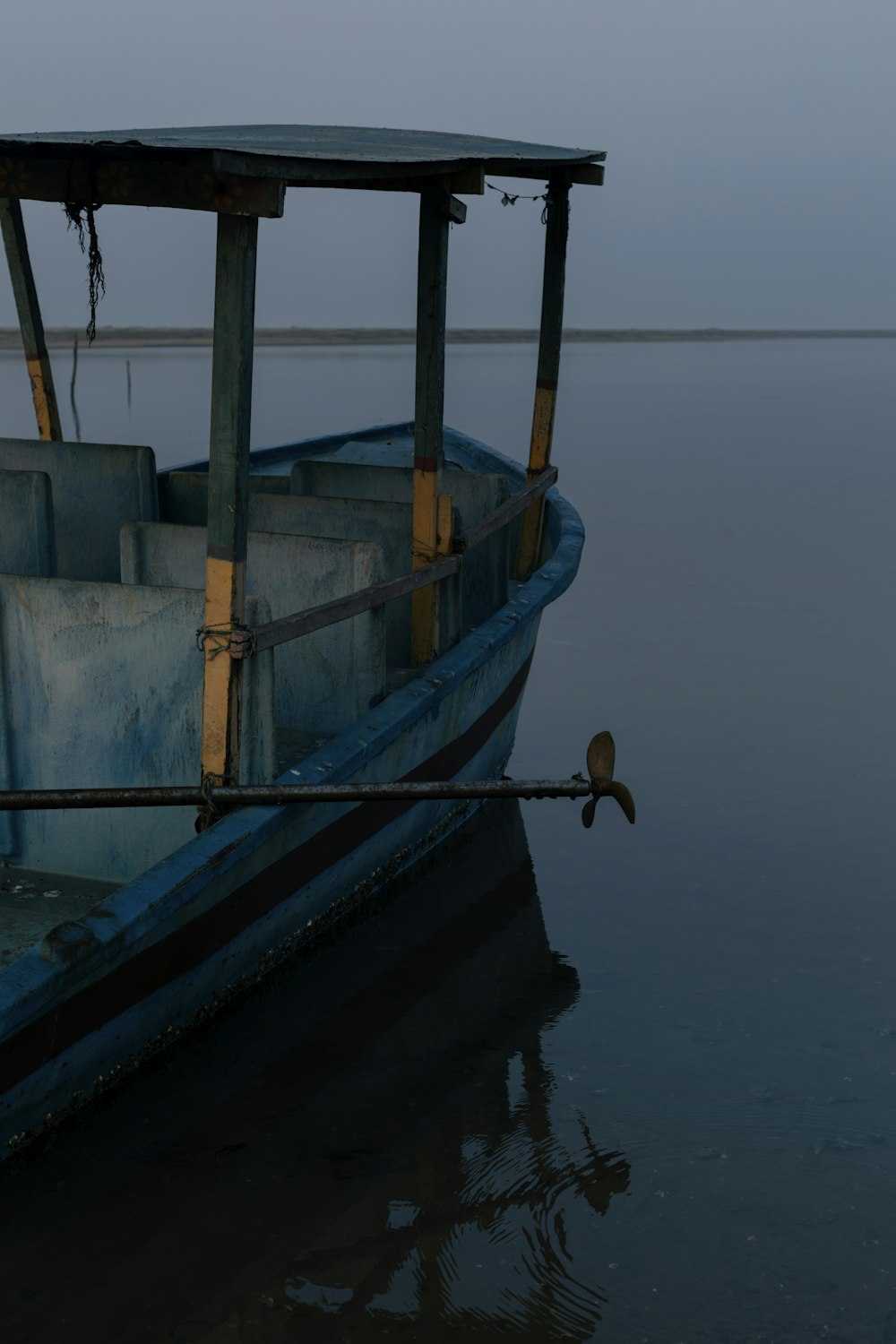 a blue boat sitting on top of a body of water