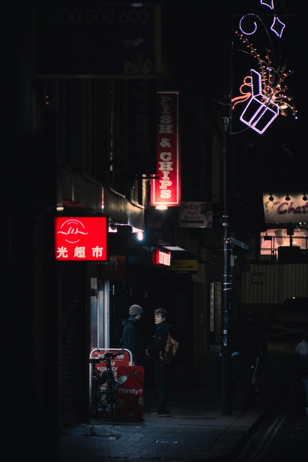 a dark city street at night with neon signs