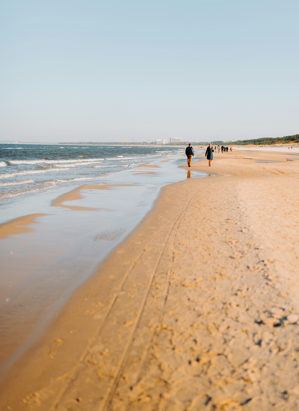 Un par de personas caminando por una playa junto al océano