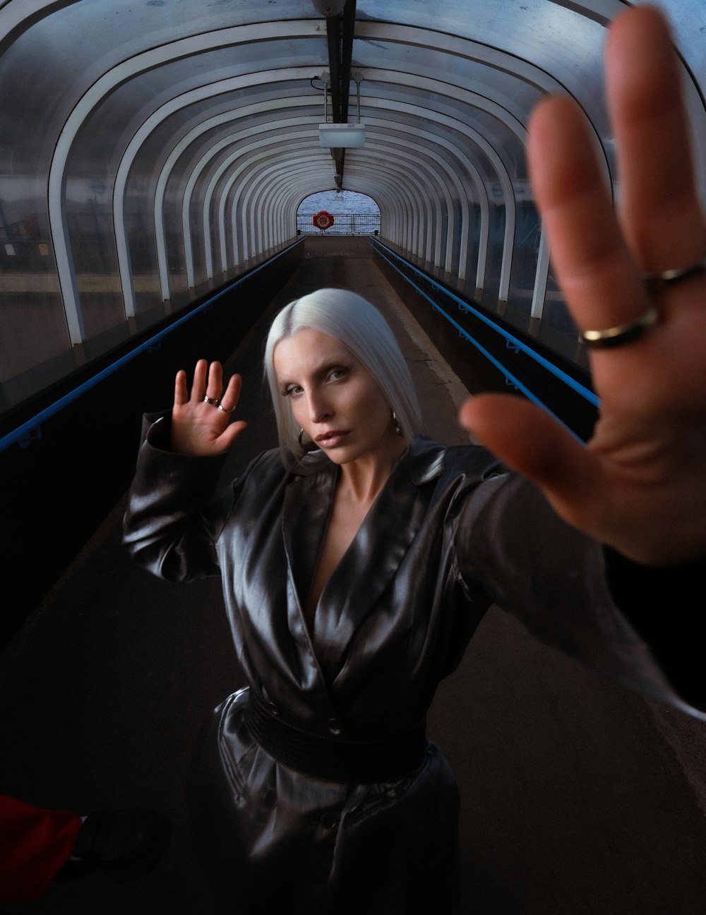 a woman in a black dress standing in a tunnel