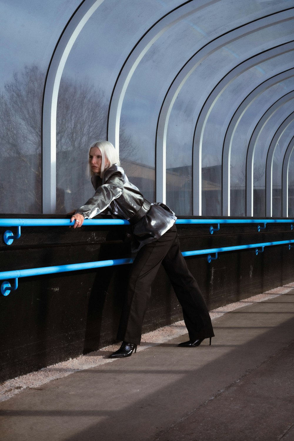 a woman leaning against a wall with her hand on the rail
