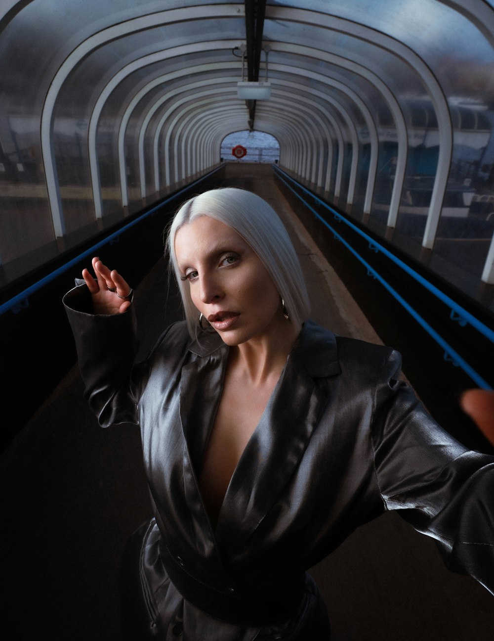 a woman with white hair standing in a tunnel