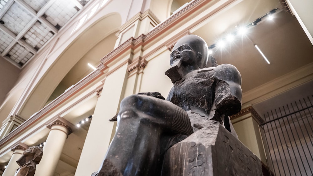 uma estátua de uma pessoa sentada em um banco