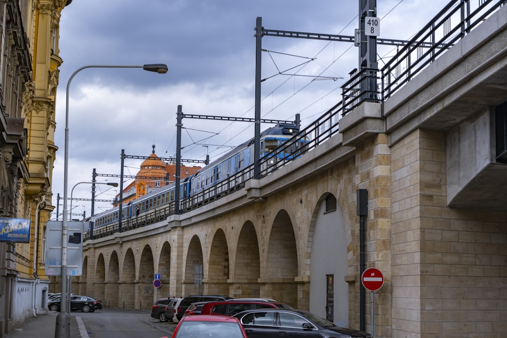 a train traveling over a bridge over a street