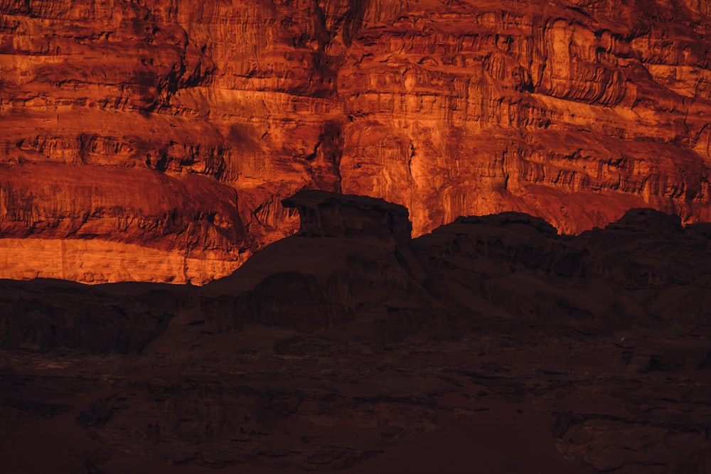 a red rock formation with a mountain in the background