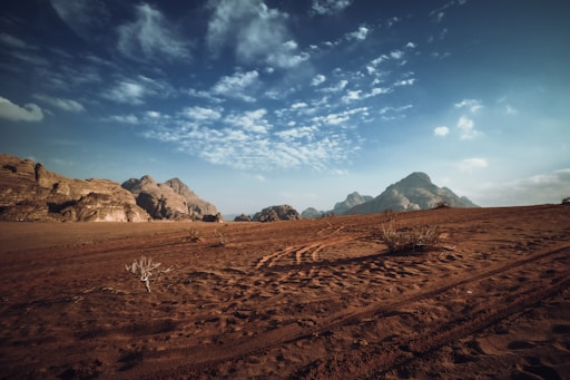 A panoramic shot of the Wadi Rum desert with red sand dunes.