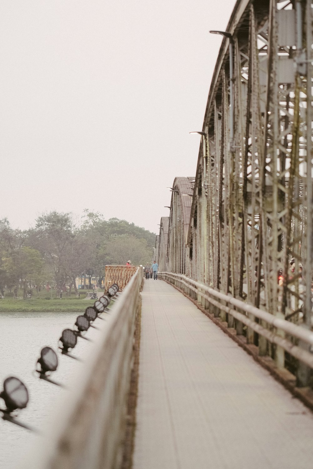 a group of birds sitting on the side of a bridge