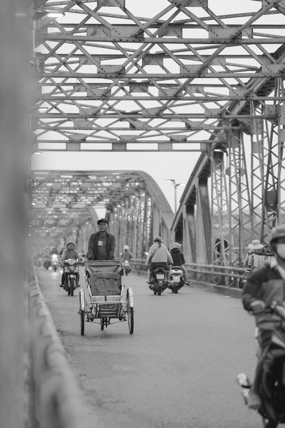 a group of people riding motorcycles on a bridge