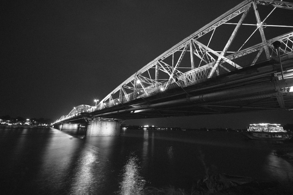Una foto en blanco y negro de un puente por la noche