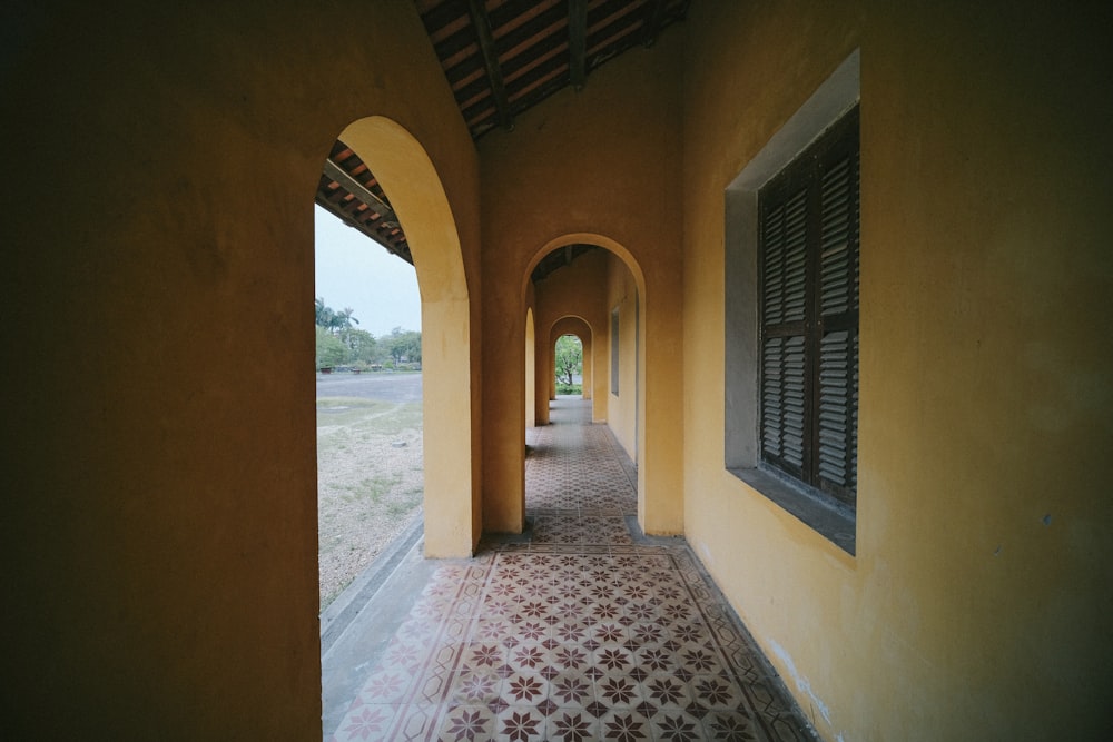 a long hallway with a tiled floor and arched windows