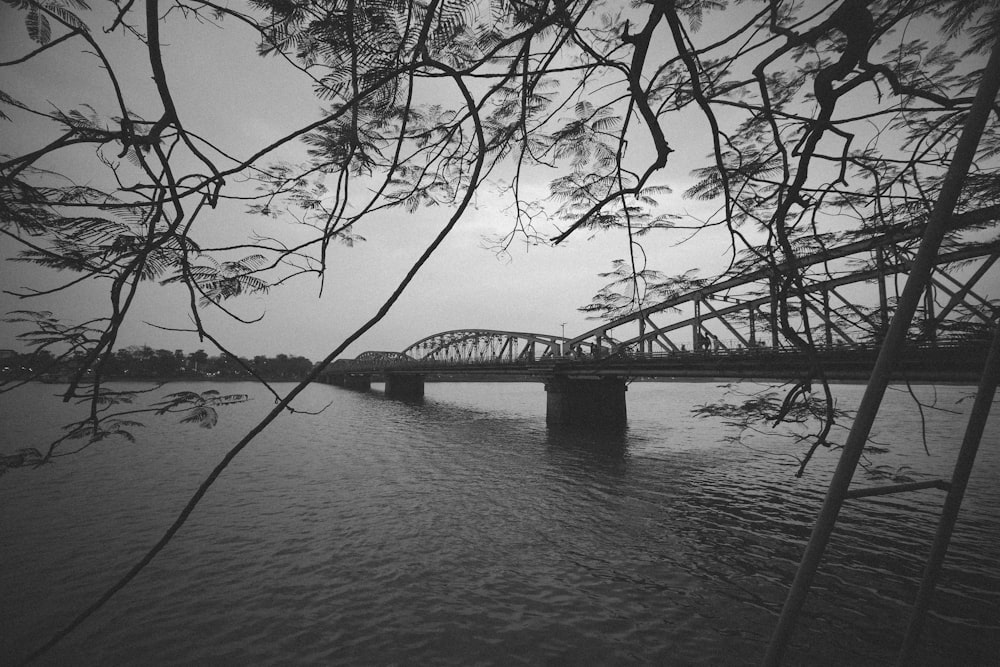 Une photo en noir et blanc d’un pont au-dessus d’une rivière