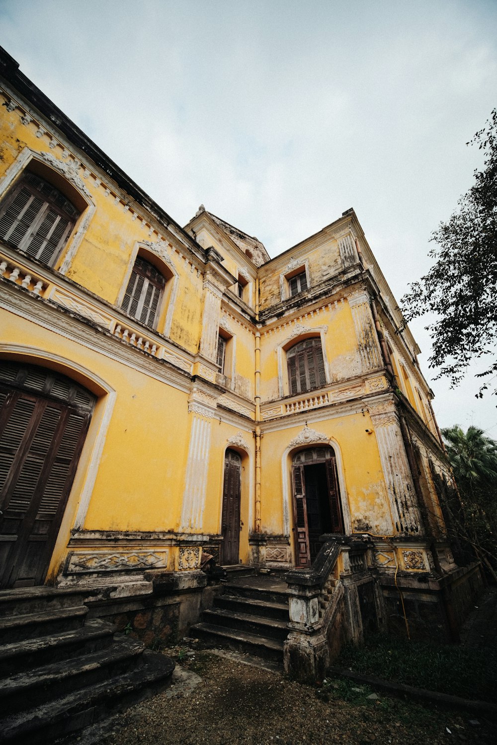 an old yellow building with stairs leading up to it