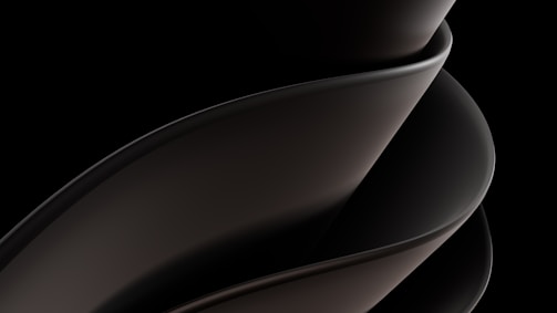 A sleek, smooth, and abstract form consisting of overlapping curved surfaces, primarily in dark tones and gradients. The design is fluid and modern, suggesting movement and elegance.