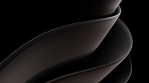 A sleek, smooth, and abstract form consisting of overlapping curved surfaces, primarily in dark tones and gradients. The design is fluid and modern, suggesting movement and elegance.