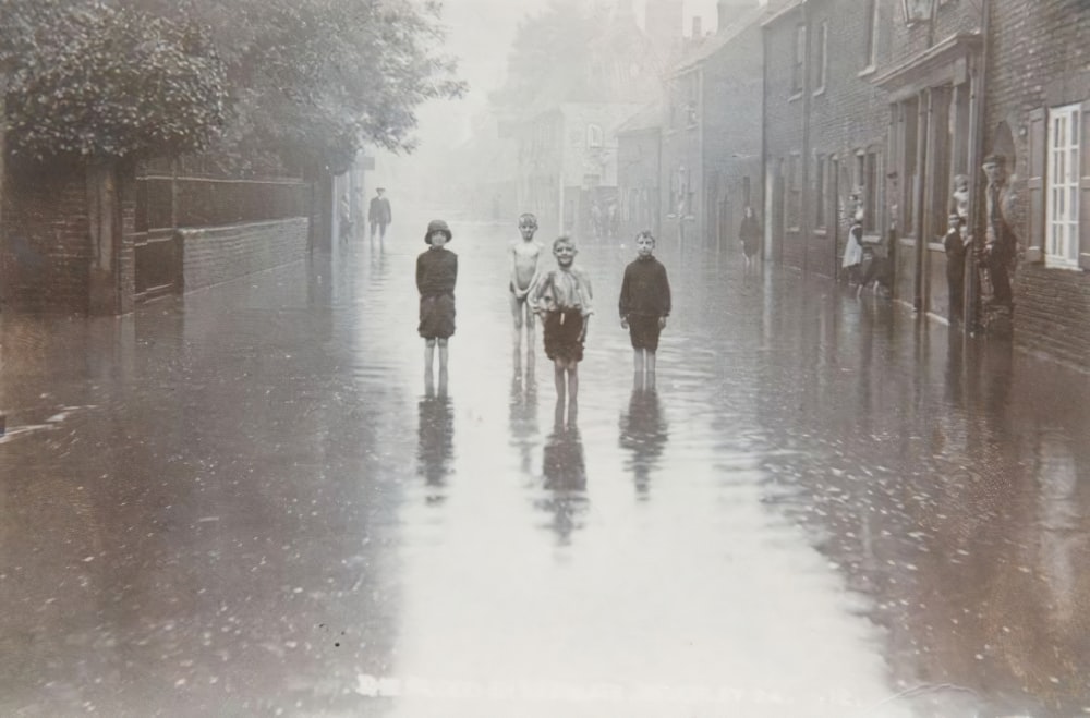 a group of people walking down a street in the rain
