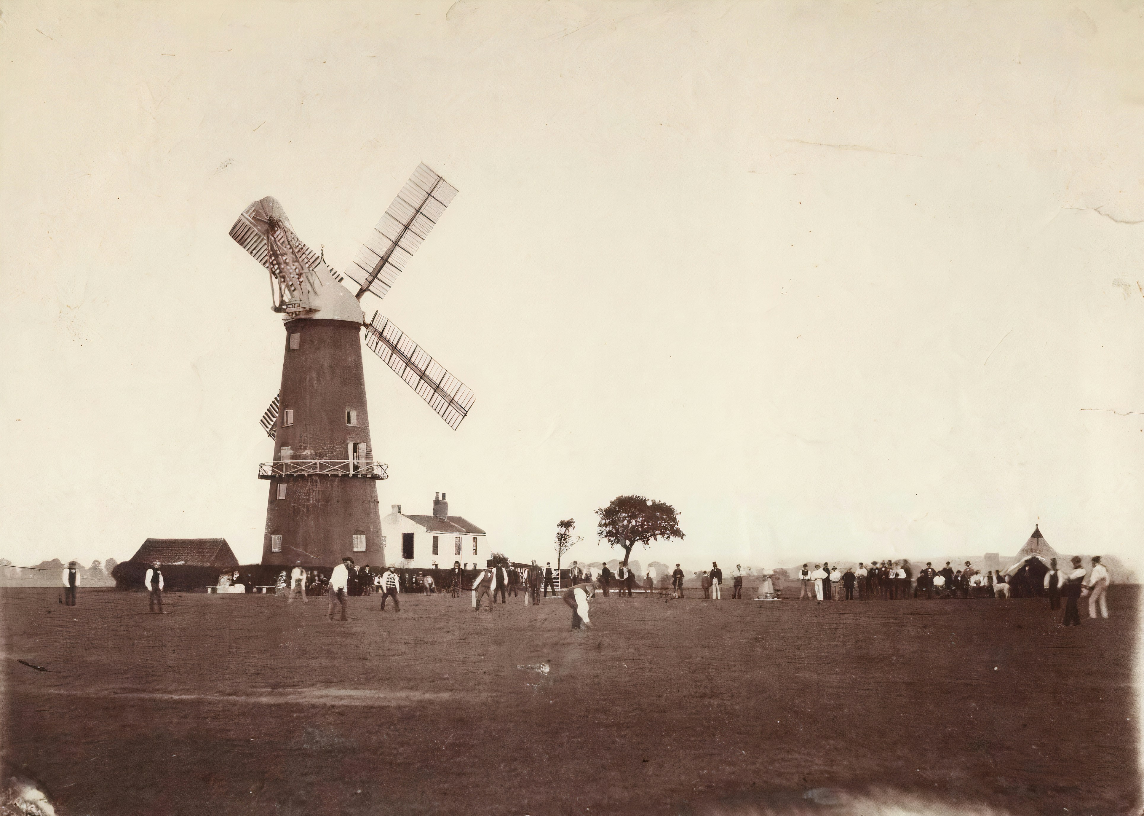a group of people standing around a windmill