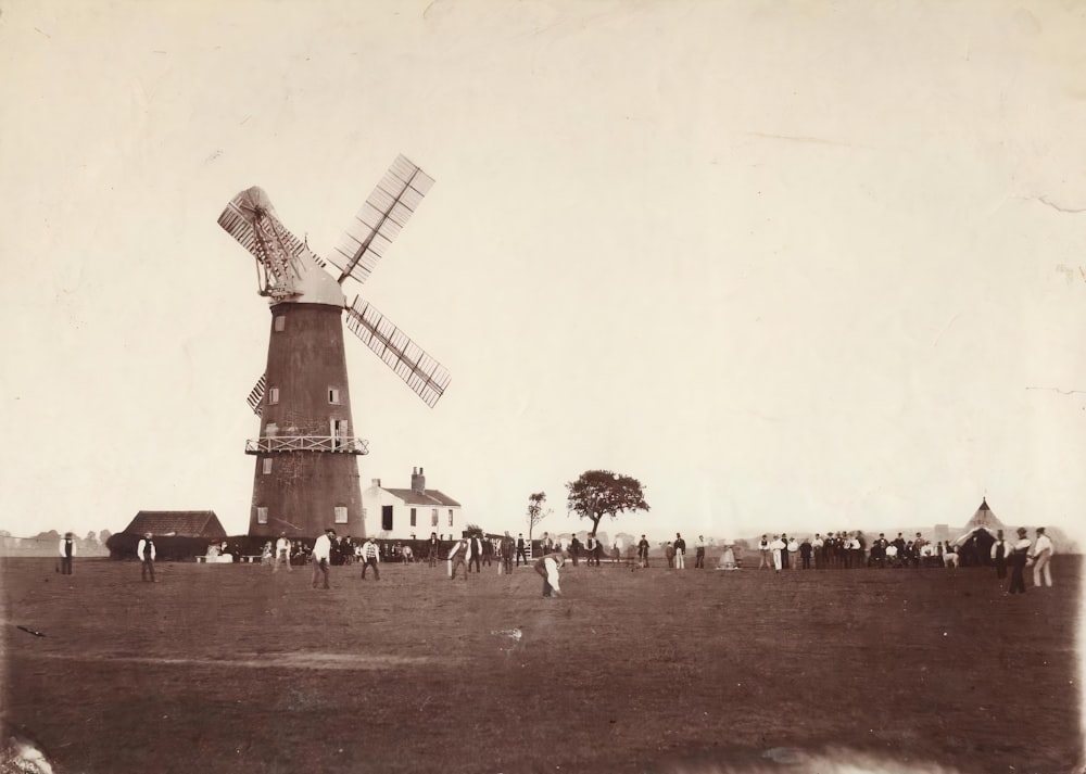 a group of people standing around a windmill