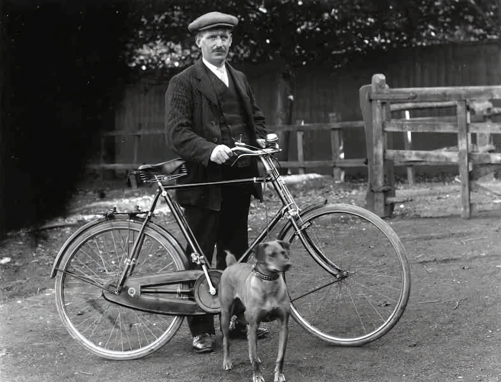 a man standing next to a dog and a bicycle