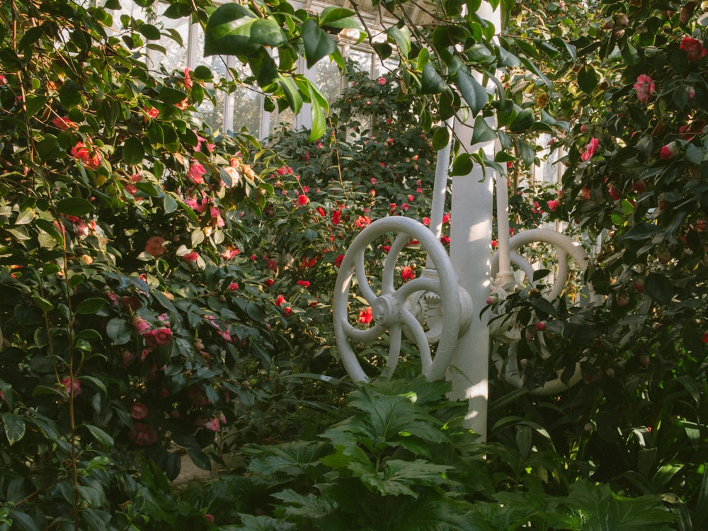 a white sculpture sitting in the middle of a garden