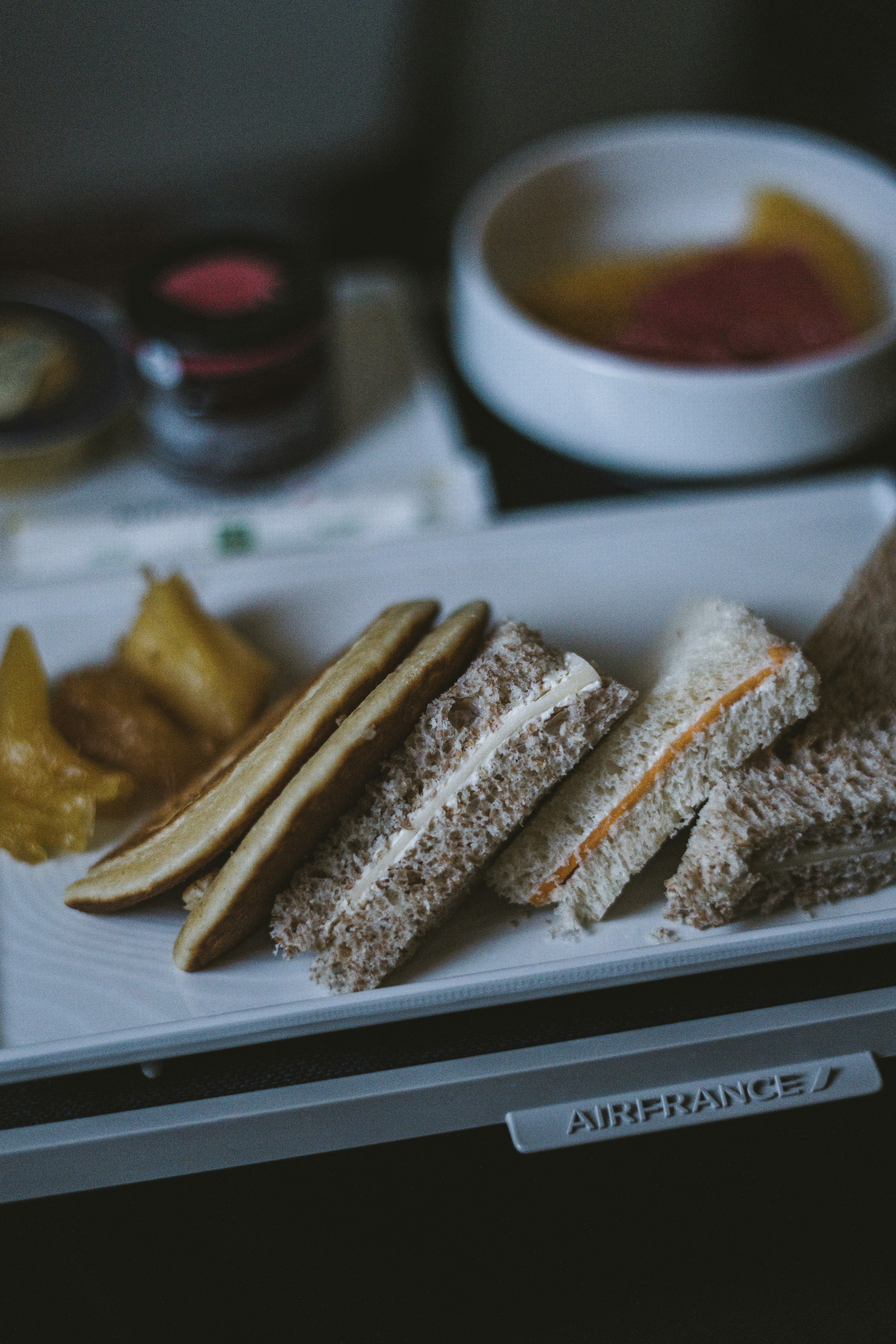 ein weißer Teller mit Sandwiches und Gurken