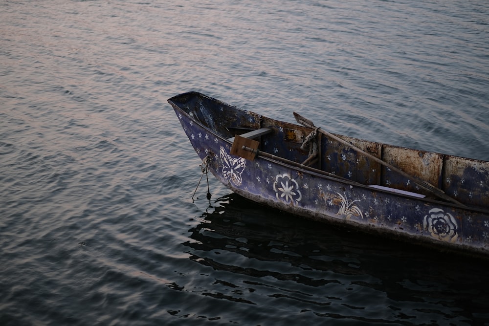 a rusty boat floating on top of a body of water