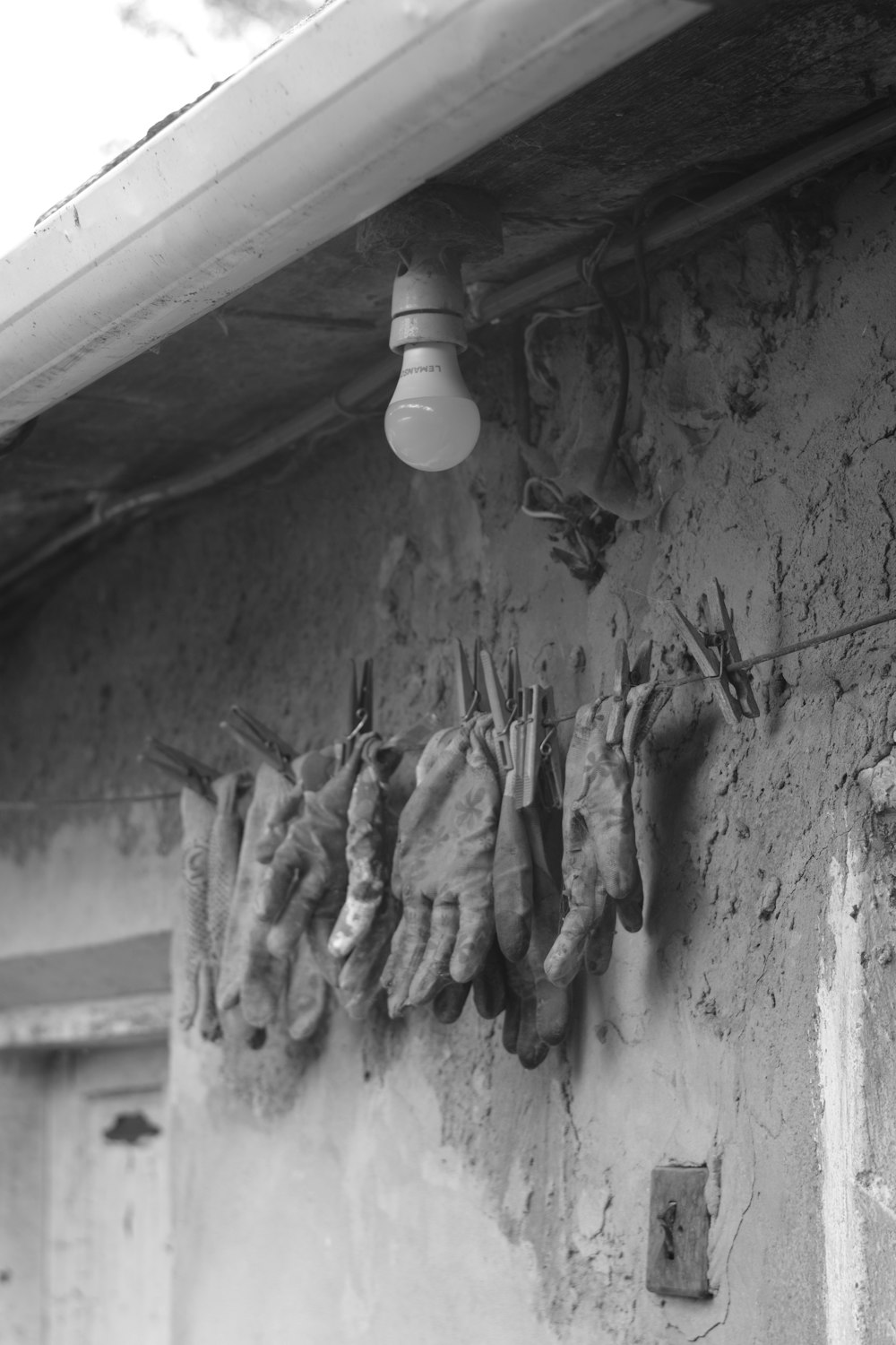 a black and white photo of gloves hanging on a wall