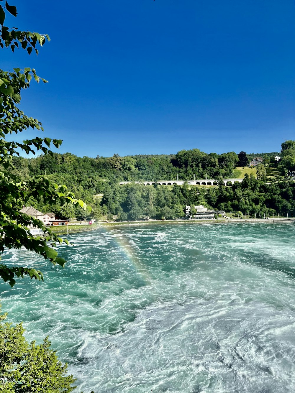 a view of a river with a bridge in the background