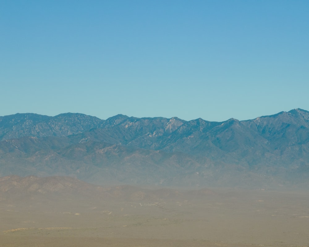 a mountain range in the distance with a blue sky