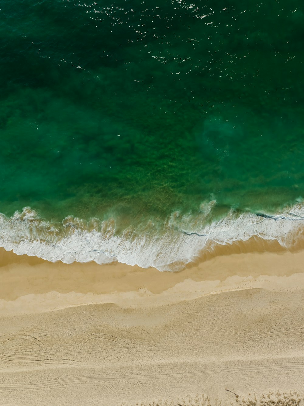 an aerial view of a sandy beach and ocean