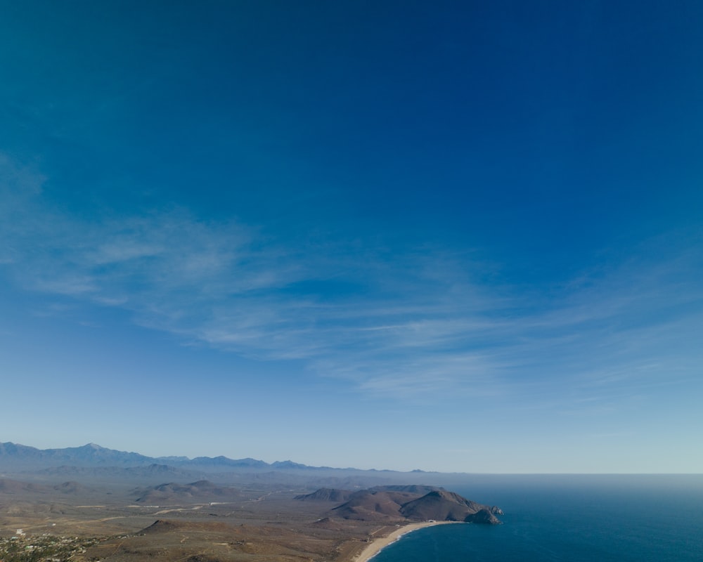a view of the ocean and mountains from the top of a hill