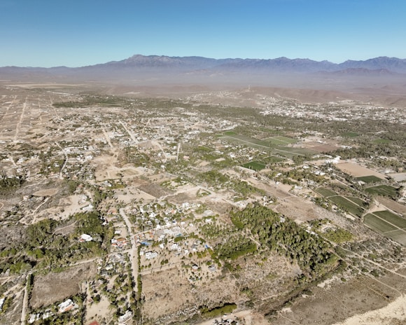 Aerial shot showing the layout of the Las Chacras lots with surrounding natural beauty and distant mountain peaks.