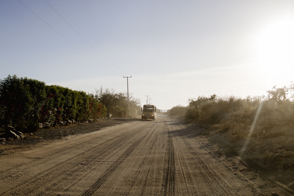 a truck is driving down a dirt road