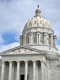 the dome of a building with columns and a cross on top