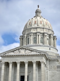 the dome of a building with columns and a cross on top