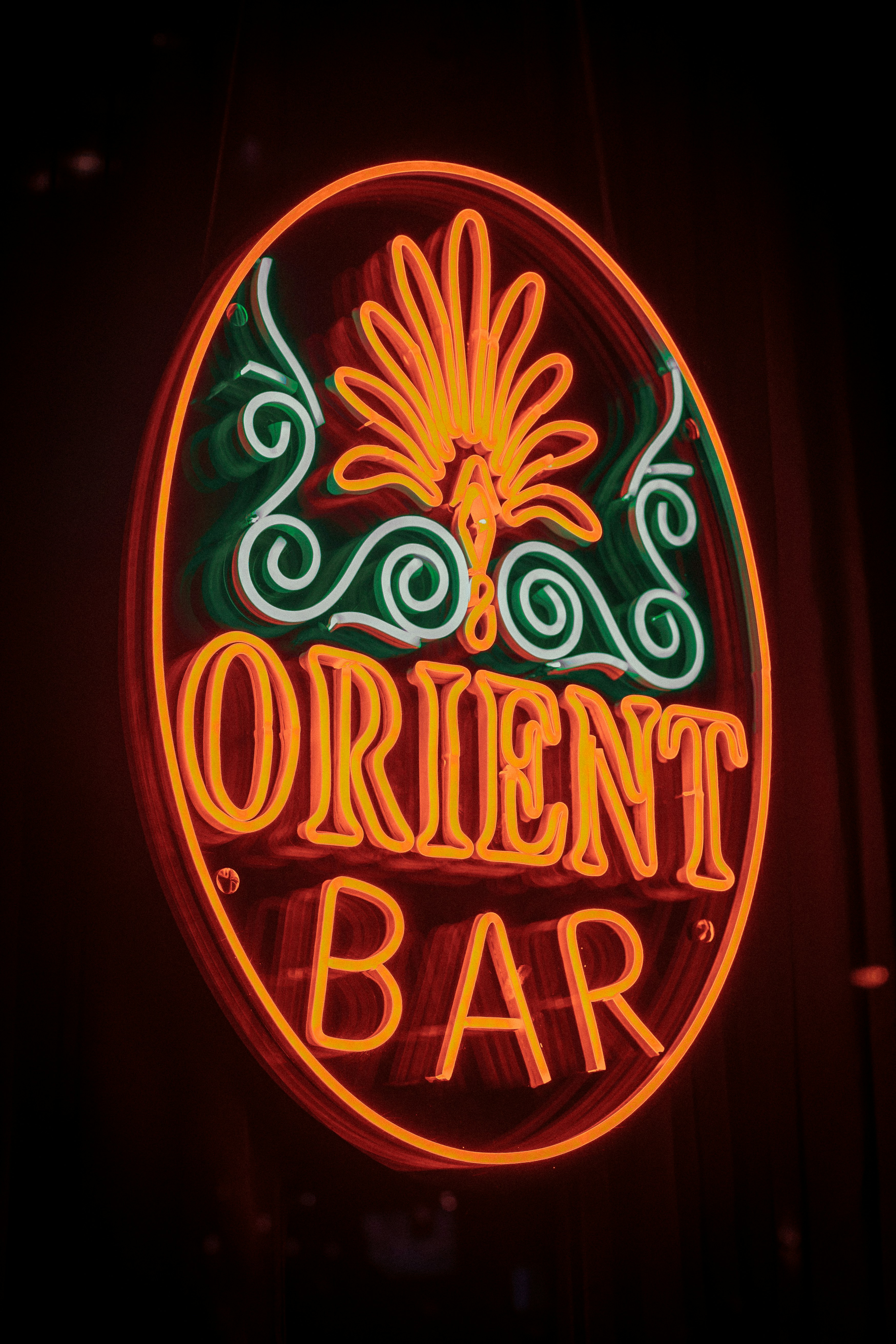 Un'insegna al neon che dice Orient Bar sul lato di un edificio