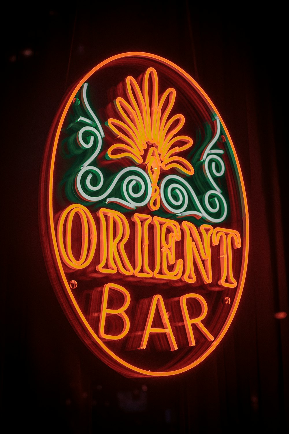 a neon sign that says orient bar on the side of a building