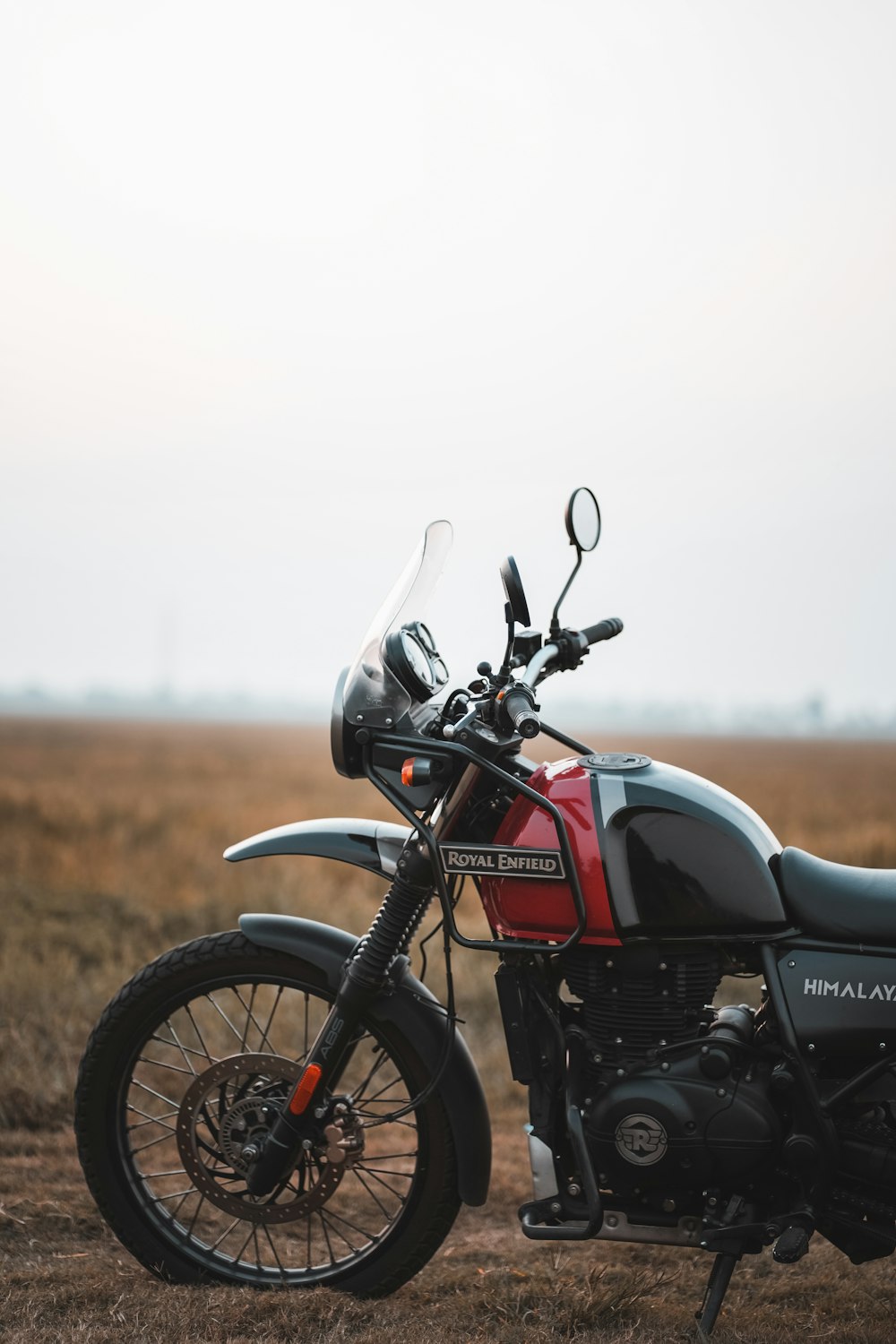a motorcycle parked on a dirt road in a field