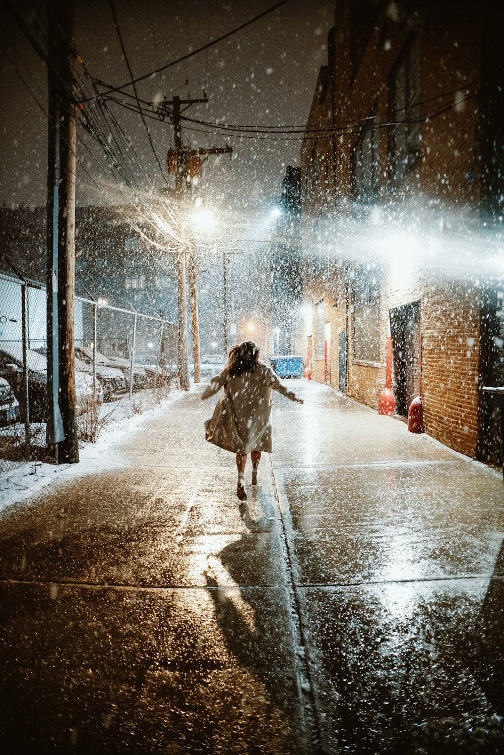 a woman walking down a street in the snow