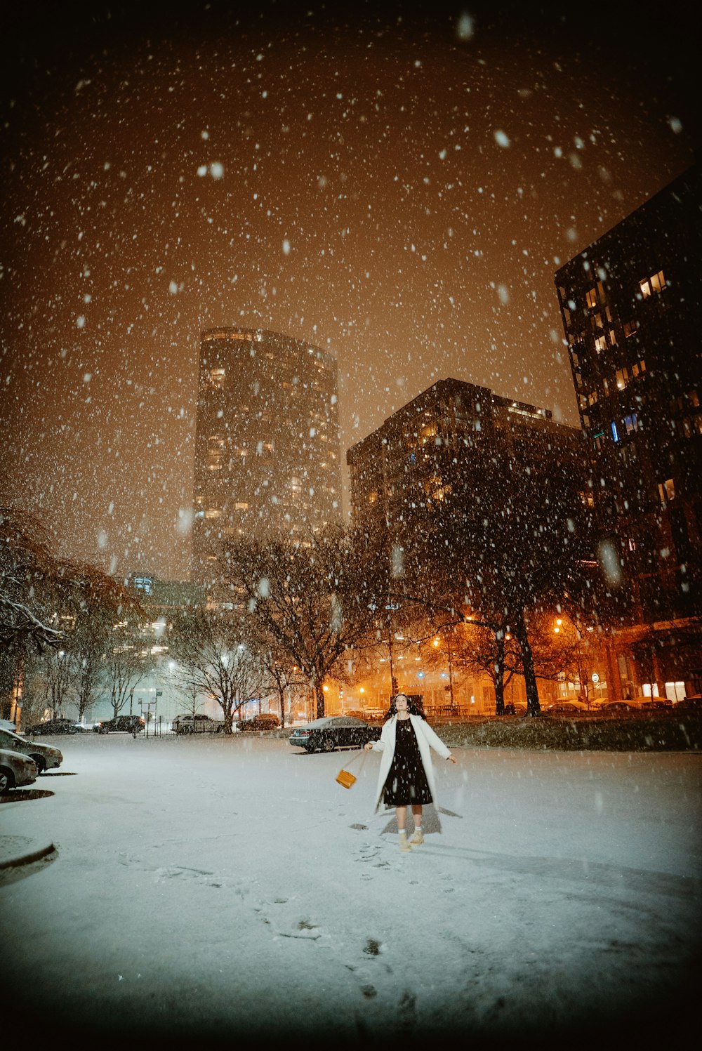 a person walking in the snow in a city at night