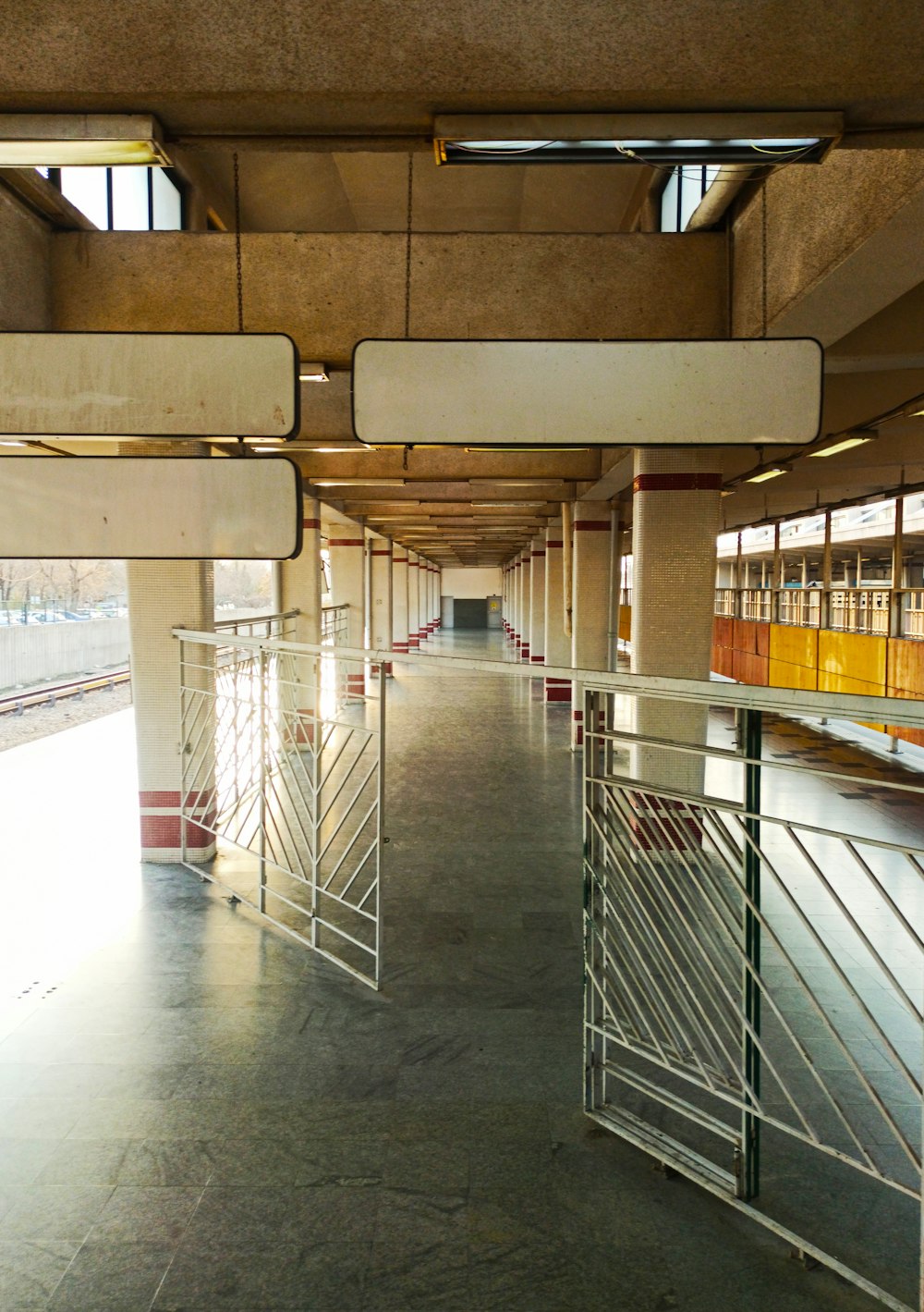 a long hallway with metal railings and windows